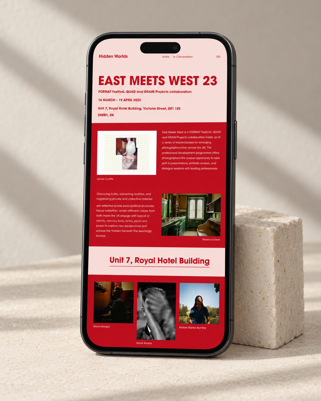 Hidden Worlds exhibition website displayed on a phone, with red and pale pink pages